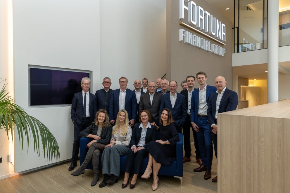 Groepsfoto van medewerkers van Fortuna Financial Group in een moderne kantooromgeving.
