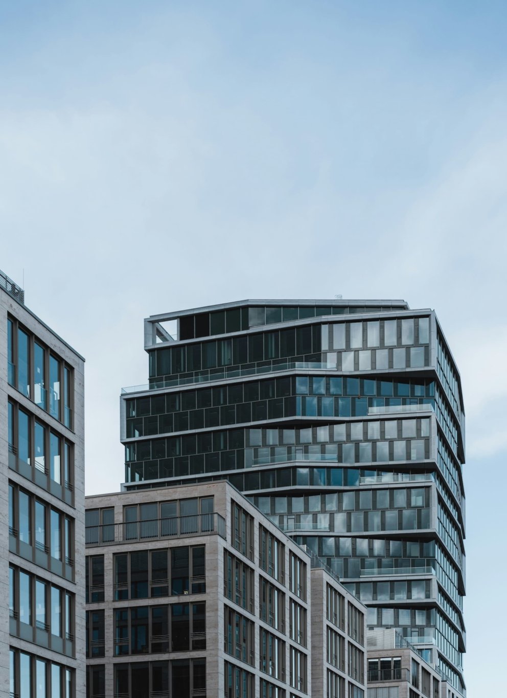 Moderne kantoorgebouwen met glazen gevels onder een blauwe lucht.
